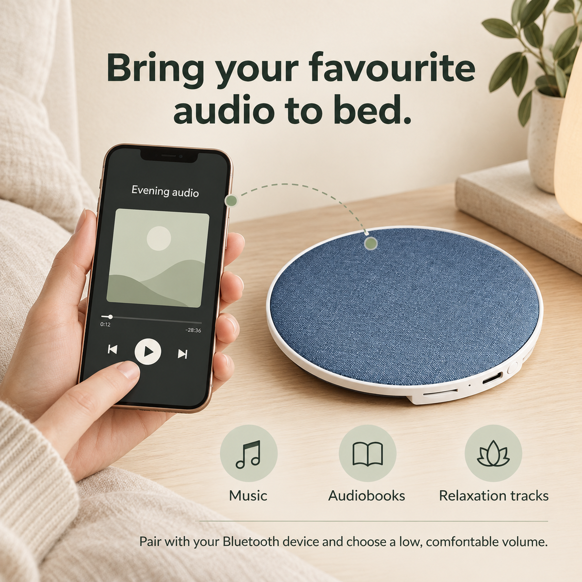 Blue pillow speaker beside a phone playing audio, with music, audiobook and relaxation track options.